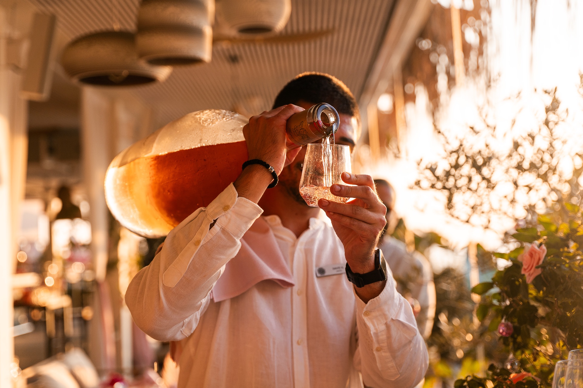 Bartender pouring rosé at golden hour during Rosé Days